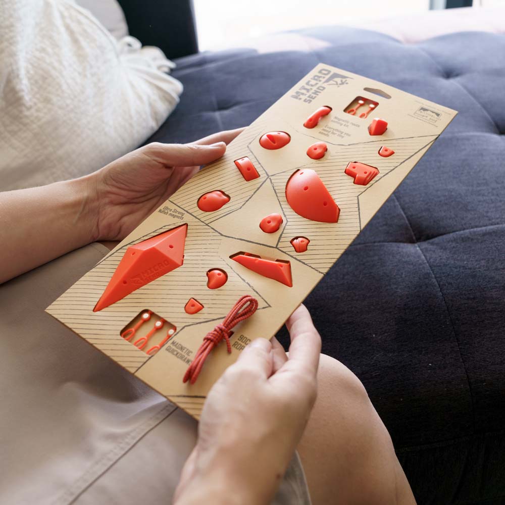 Hands holding orange micro send packaging