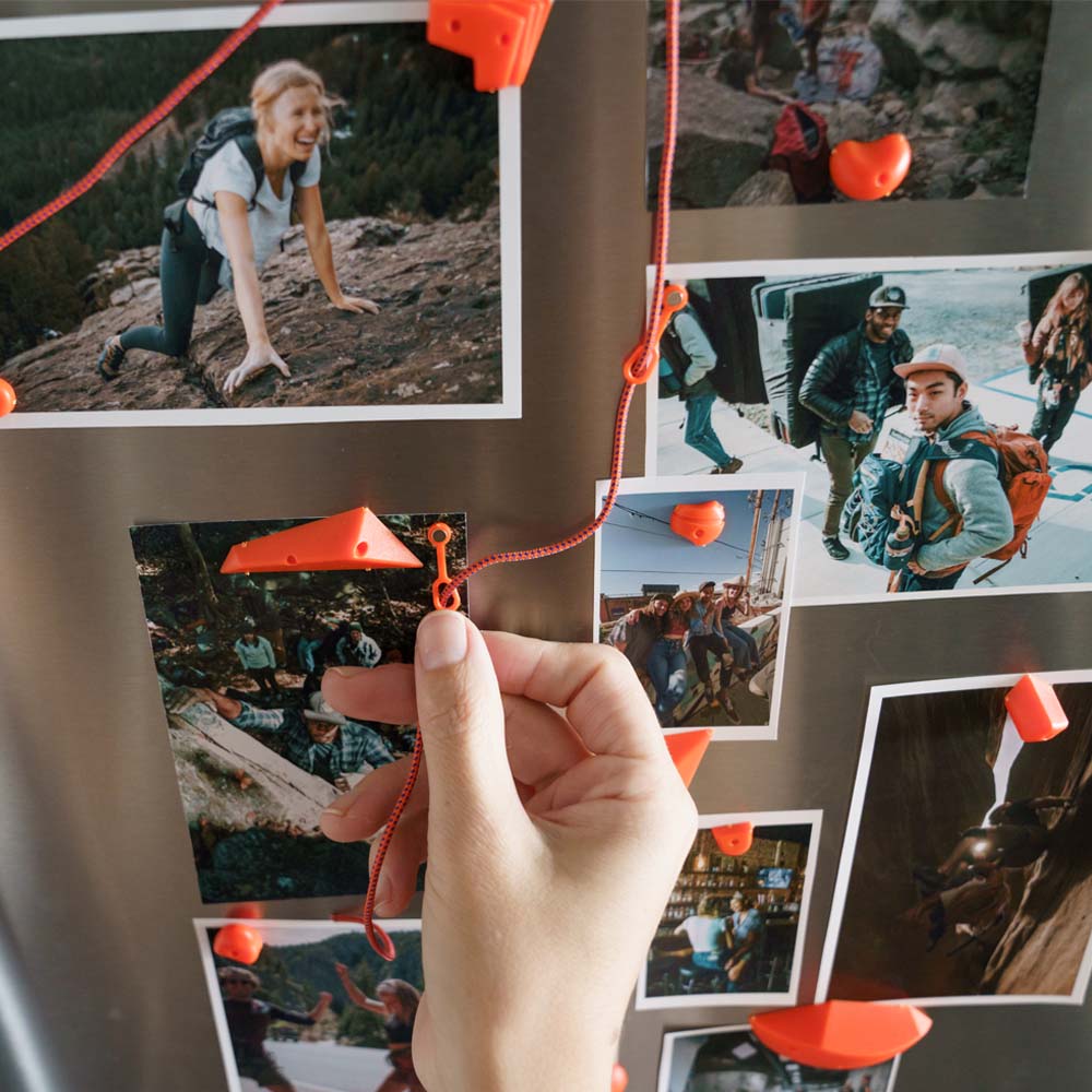 Hand pulling small rope through small carabiner on fridge